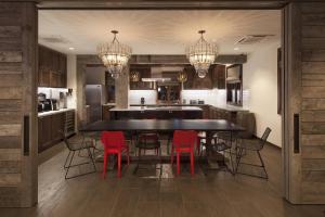 圣巴巴拉Moxy Santa Barbara的厨房配有大型黑桌和红色椅子
