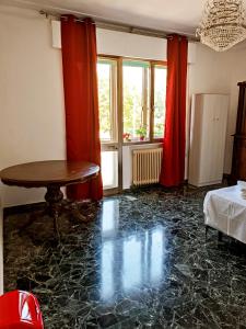 泰塞拉Locazione Turistica的客厅配有桌子和红色窗帘