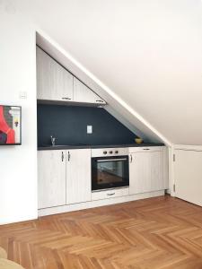 诺维萨德Apartman NS Dan PRIVATE PARKING的阁楼厨房配有白色橱柜和微波炉。