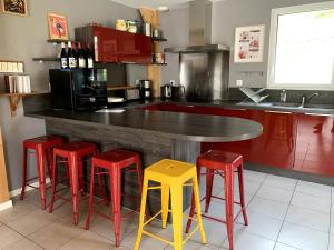 勒蒙多尔Chalet Las Abelhas的厨房配有带4张红色和黄色凳子的台面