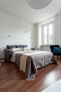 韦尔巴尼亚A central quiet sunny studio in Verbania的白色卧室配有一张带毯子的大床