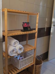 科洛皮奥Helen's cozy studio (close to the airport)的浴室内带毛巾和篮子的木制架子