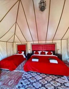 梅尔祖卡Luxury Desert Camp的一间帐篷内带两张红色床铺的卧室
