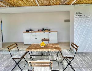 卡普里Casa Nannina - Seaview Terrace with Jacuzzi in Capri的一张桌子,上面有两把椅子和一碗水果