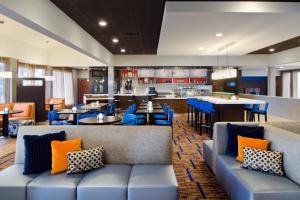 马里兰高地圣路易斯西港广场万怡酒店的一间设有蓝色沙发的餐厅和一间酒吧