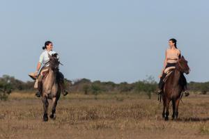 Uguay安心角乡村民宿的两个在田野骑马的女人