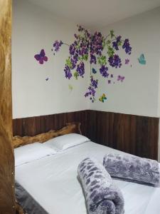 菲兰迪亚Hostal Casa Madrigal的卧室配有一张墙上鲜花的床