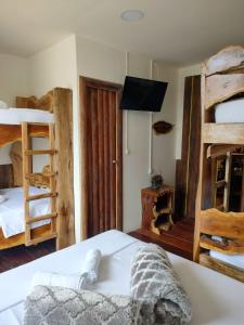 菲兰迪亚Hostal Casa Madrigal的一间卧室配有两张双层床和电视