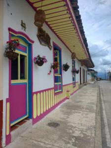 菲兰迪亚Hostal Casa Madrigal的街道上一座建筑,有色彩缤纷的门窗