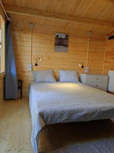 方Parque de Campismo de Fão的木制客房内的一间卧室,配有一张床