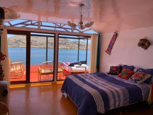 普诺Uros TITIKAKA the Best lodge的一间卧室配有一张床,享有水景