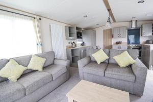 洛斯托夫特Beautiful 6 Berth Caravan With Full Sea Views For Hire In Suffolk Ref 68002cr的一间带两张沙发的客厅和一间厨房