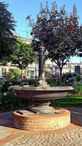 蒙泰内罗迪比萨恰Corte Soriano的公园里的一个喷泉,有树木和建筑物