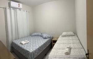 巴雷里尼亚斯Lençóis Confort - BL05-AP02的一间卧室配有两张床,床上放着一只狗。
