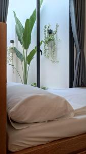 罗夷Khanh Thy Homestay Lagi的一间卧室配有一张床和一个植物窗户