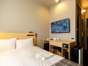 福冈里格纳福雷斯塔酒店的酒店客房设有一张带书桌的床和一台电视。