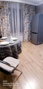 阿拉木图Алматушечка的一间带桌子和冰箱的用餐室