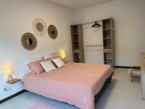 圣若瑟La KAZA-De-LINE的卧室配有一张大床,配有粉色床单和枕头