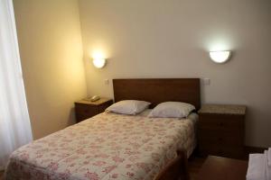 波尔图爱克扎果酒店的一间卧室配有一张大床和两个枕头