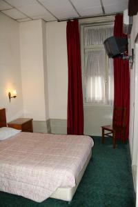 波尔图爱克扎果酒店的一间卧室配有床和红色窗帘的窗户