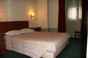 波尔图爱克扎果酒店的一间卧室设有一张大床和一个窗户。