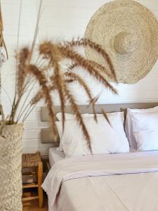 莫沙夫拉莫特Sky Travelers סקיי מטיילים的一间卧室配有白色床单和植物