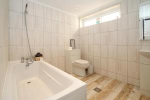 拉纳克Deluxe Apartment的白色的浴室设有浴缸和卫生间。