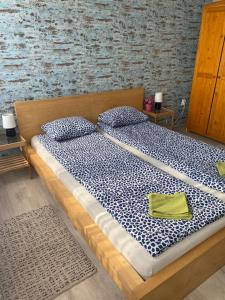 格德勒Dózsa Apartman的一张配有蓝色和白色床单及枕头的大床