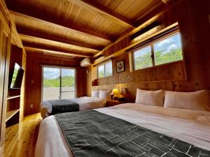 本部Resort & Villa RYUNON的一间带两张床的卧室,位于带窗户的房间内