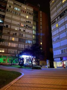 格德勒Dózsa Apartman的夜间在建筑物前的一条空的街道