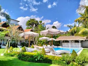 坎古37 Sunset Village Bali的一个带游泳池、椅子和遮阳伞的度假村