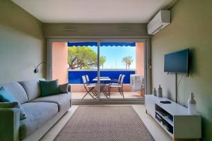 弗雷瑞斯Apartment in Fréjus Plage by the seaside with direct access to the beach的客厅配有沙发和桌子