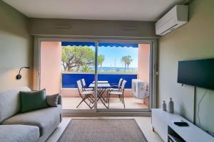 弗雷瑞斯Apartment in Fréjus Plage by the seaside with direct access to the beach的客厅配有沙发和桌子