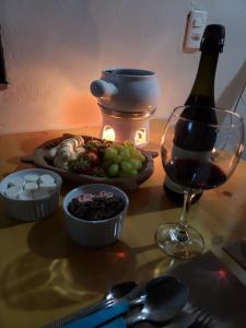 蒙特韦尔迪Chalé Sonho Diniz 2的一张桌子,上面放着一盘食物和一杯葡萄酒