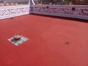 Aït TiourhzaDar Ilyana的红色地板上一个空的庭院,有锅