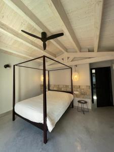 帕尔斯Casa Palma Pals 2的一间卧室配有一张天蓬床和吊扇