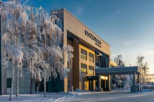 安克雷奇Courtyard by Marriott Anchorage Airport的前面有雪覆盖的树木的建筑