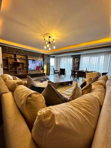 恰纳卡莱Akhome - Luxury dublex apartment的客厅配有大沙发和电视