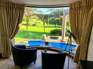 哈特比斯普特The Villa Luxe Hartbeespoort Spacious Golf & Wildlife Estate的客厅设有窗户,享有游泳池的景色