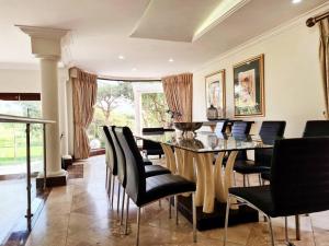 哈特比斯普特The Villa Luxe Hartbeespoort Spacious Golf & Wildlife Estate的一间带桌子和黑色椅子的用餐室