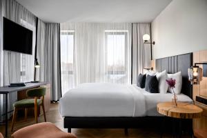 阿斯米尔Renaissance Amsterdam Schiphol Airport Hotel的酒店客房设有一张大床和一张书桌。