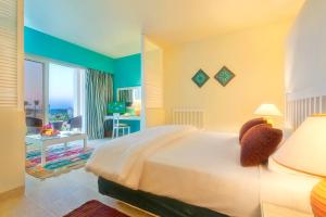 马特鲁港凯撒湾度假酒店的一间卧室配有一张床,另一间卧室配有书桌