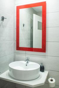 圣加利尼Christof Studios的浴室设有白色水槽和红色框框镜子