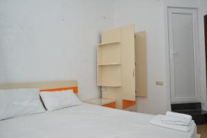 巴统Orange Home Hotel的卧室配有白色的床和橱柜。
