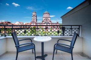 阿然德洛维克Hemingway LUX的阳台设有两把椅子和一张桌子,享有建筑的景色