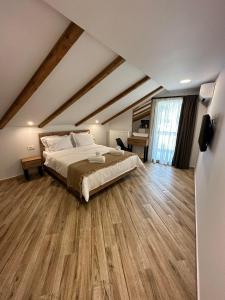 卡兰巴卡Meteora Sunrise的一间卧室设有一张大床,铺有木地板。