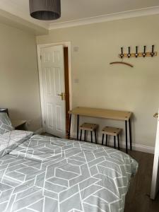 IfordPrivate room in family home的一间卧室配有一张床和一张桌子及两张凳子