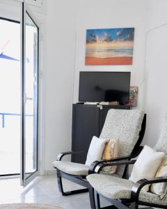 迈加洛丘里4 Ambelia paradise的客厅配有两把椅子和电视