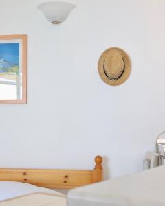 迈加洛丘里4 Ambelia paradise的挂在床边墙上的帽子