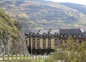 贝纳斯克San Marsial Benasque Apart Hotel的一座大建筑,背景是一座山